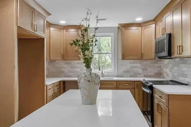 Crestone Drive kitchen with an island, wood cabinets, and a tiled backsplash