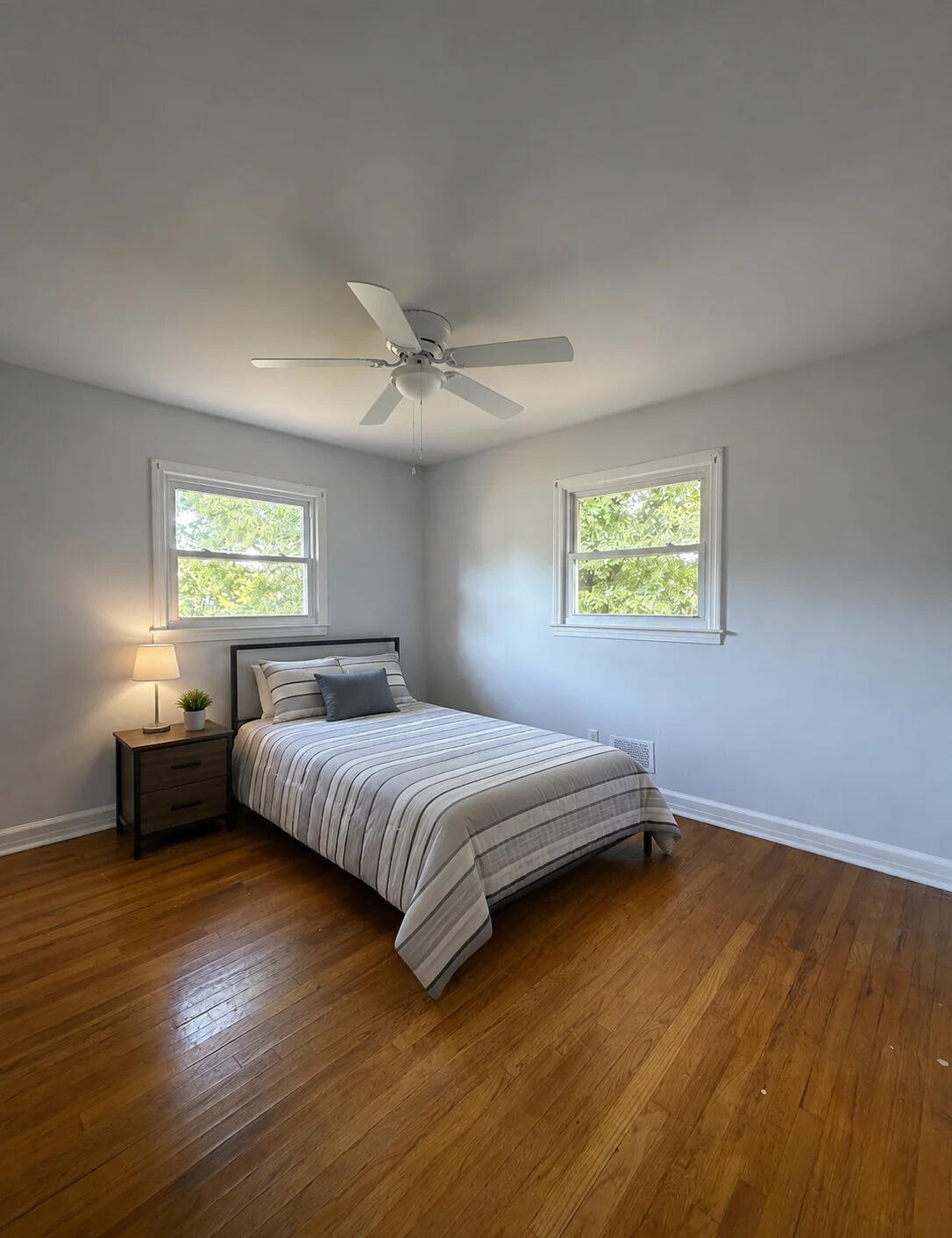 Morris Street — a cozy corner of Greenville Furnished bedroom at the Morris Street home, with two windows and hardwood floors